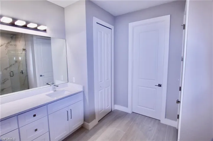 Bathroom featuring a shower with door and vanity