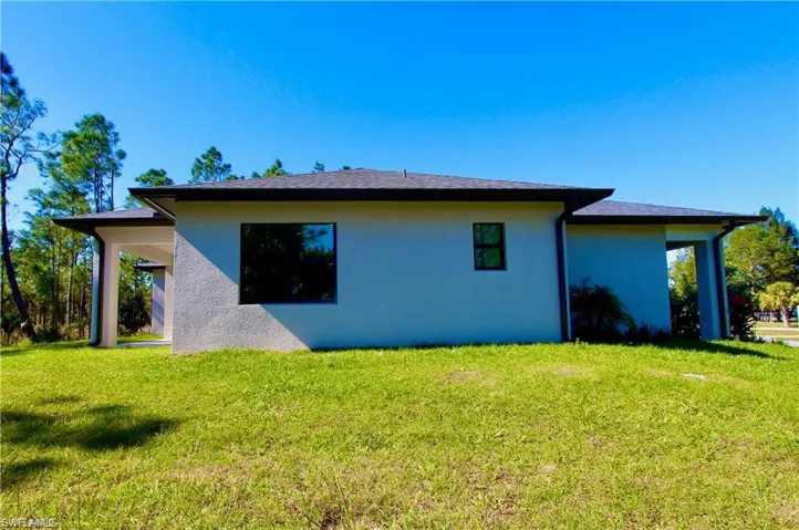Back of house with a lawn