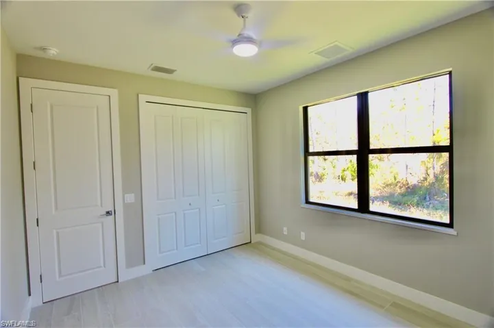 Unfurnished bedroom featuring ceiling fan, a closet, and multiple windows