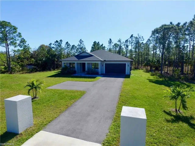 View of front of property featuring a front lawn and a garage