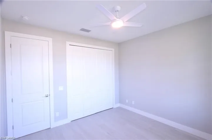 Unfurnished bedroom featuring ceiling fan and light wood-type flooring