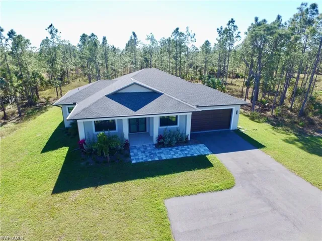 Single story home with a garage and a front yard