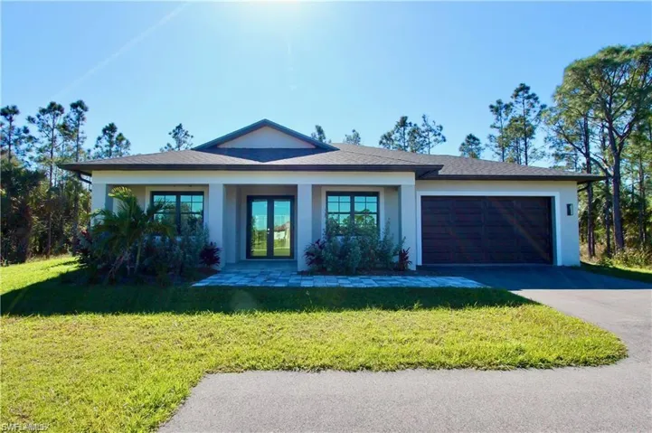 View of front of home featuring a front lawn and a garage