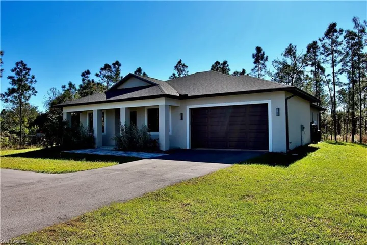 View of front of home with a front lawn and a garage
