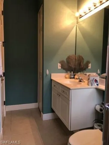 Bathroom featuring toilet, vanity, and tile patterned floors