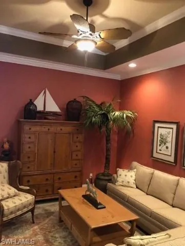 Living room with ceiling fan and crown molding