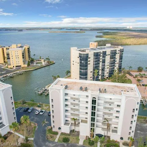 Drone / aerial view of apartment complex and a nearby body of water