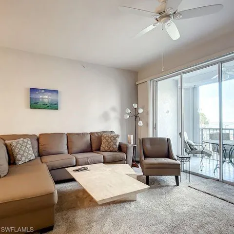 Living area featuring a ceiling fan and carpet