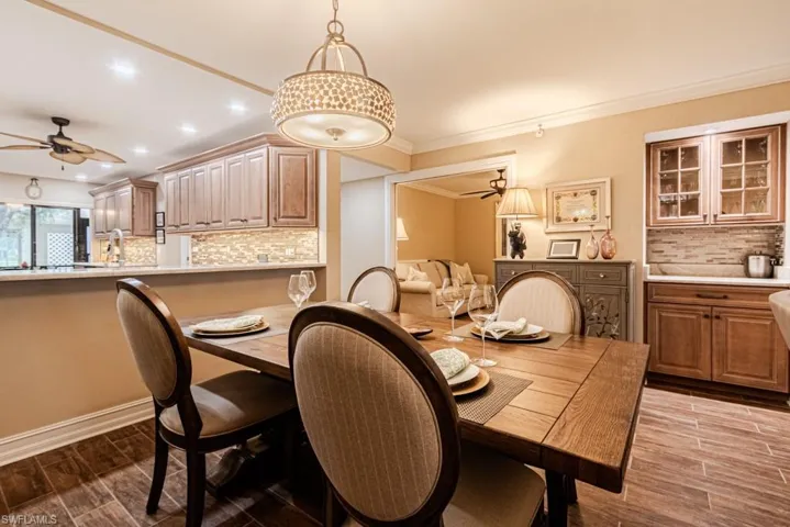Dining area with crown molding and dry bar.