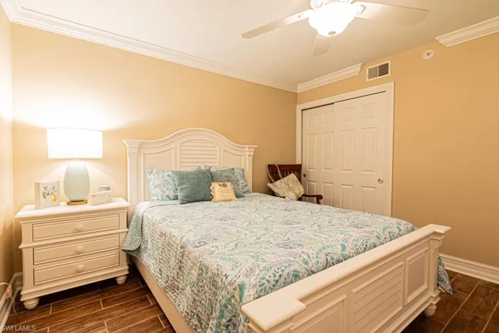Guest bedroom featuring crown molding, ceiling fan, and a closet.