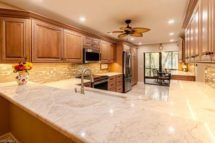 Kitchen featuring champagne toast pencil backsplash and Taj Mahal quartzite countertops.
