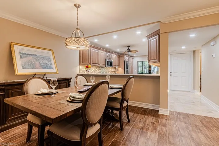 Dining space featuring ornamental molding, wood-type flooring, and ceiling fan