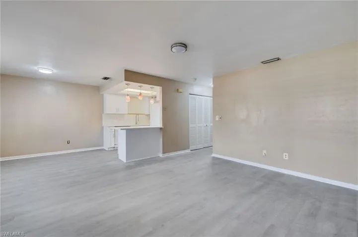 Unfurnished living room with baseboards and light wood-type flooring