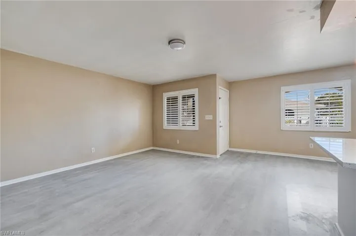 Empty room with baseboards and light wood-type flooring