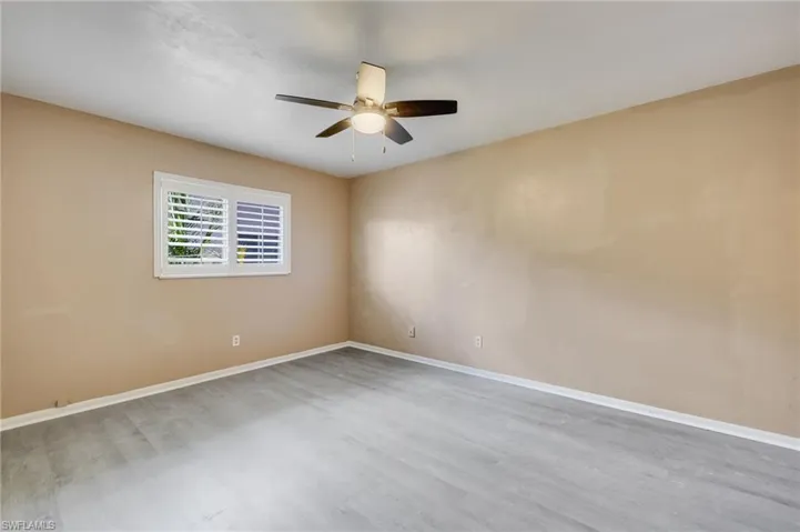Unfurnished room with wood finished floors and ceiling fan