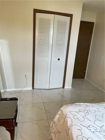 Bedroom with a closet and light tile floors