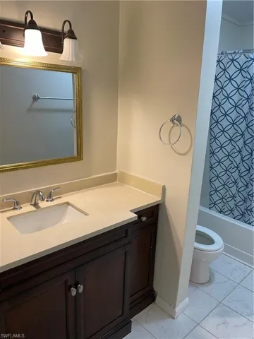 Full bathroom featuring tile flooring, vanity, and toilet