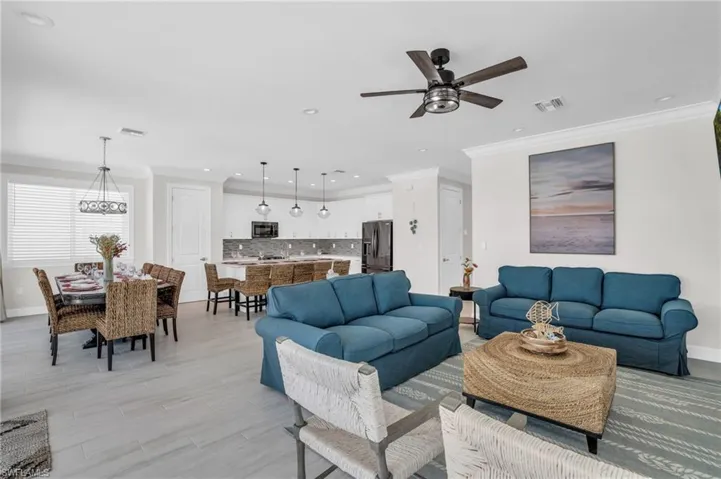 Living room with ornamental molding and ceiling fan