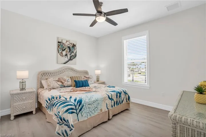 Bedroom with ceiling fan and with LVP wood-style flooring floors