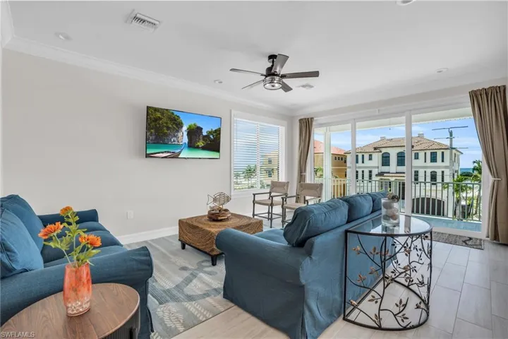 Living room featuring with LVP wood-style flooring, crown molding, and ceiling fan