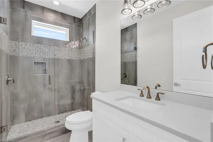 Bathroom featuring vanity, toilet, a shower with door, and wood-type flooring