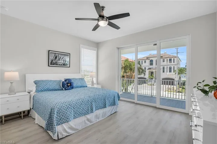 Bedroom featuring multiple windows, light wood-type flooring, ceiling fan, and access to exterior