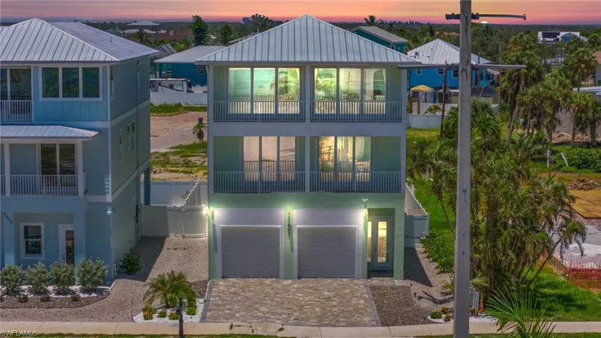 View of front of house with Gulf-facing balconies and garage