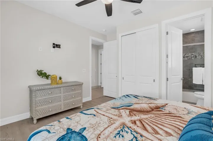Bedroom featuring ensuite bathroom, ceiling fan, a closet, and with LVP wood-style flooring