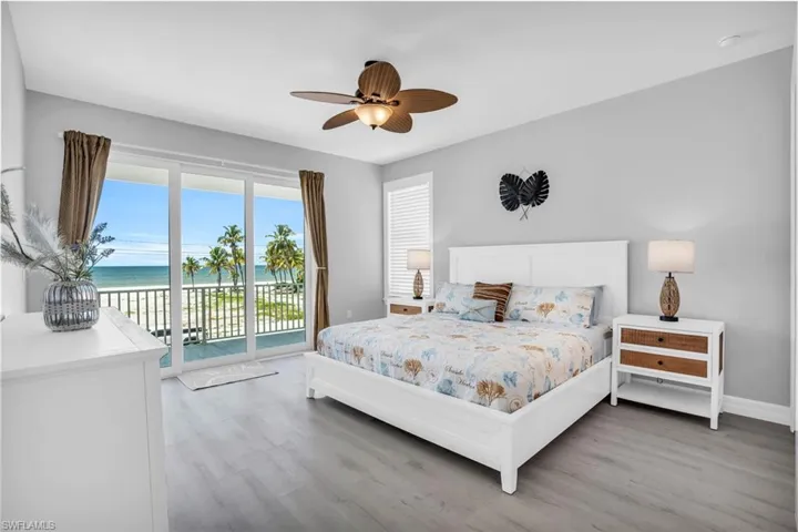 Bedroom with LVP wood-style flooring, a water view, access to outside, and ceiling fan