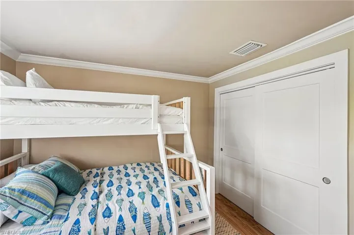 Crown molding, hardwood-style flooring, and sliding panel doors