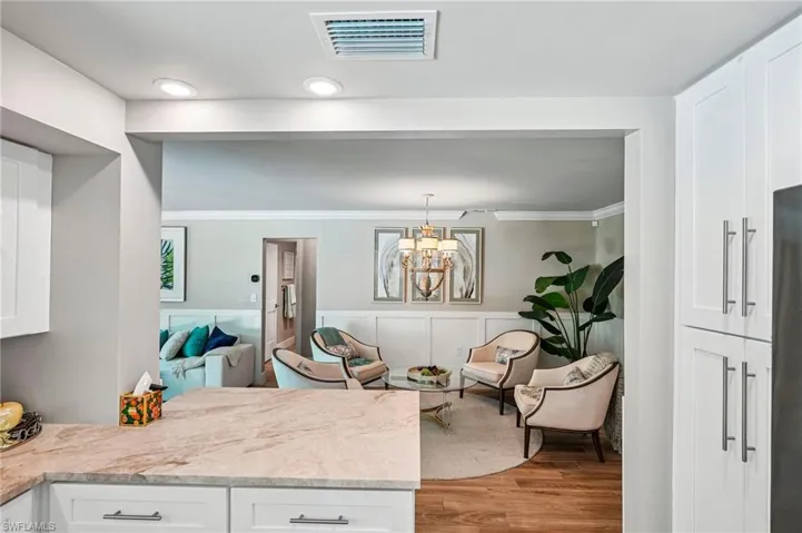 Spacious interior with recessed lighting, crown molding, and wood-finish flooring