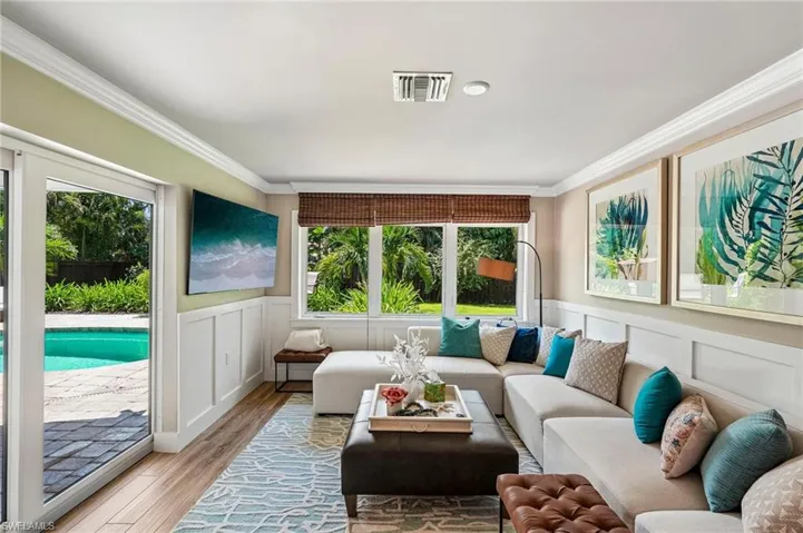 Recessed lighting, crown molding, wood-finish flooring, full-light glass door, and large picture windows