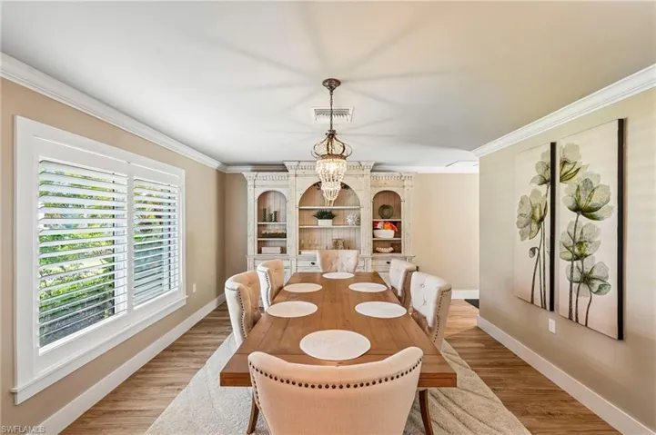 Wood-finish flooring, crown molding, a built-in display cabinet, and plantation shutters