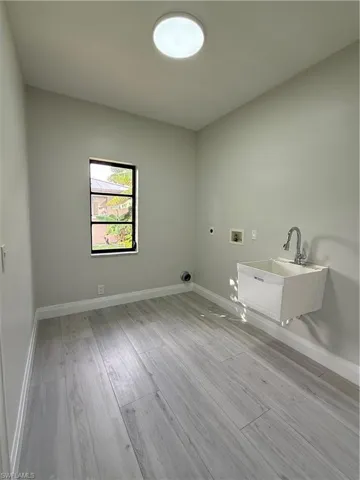 Laundry room with hookup for a washing machine, light wood-type flooring, and electric dryer hookup