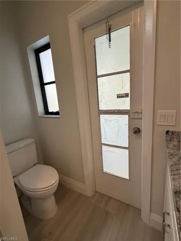 Half bathroom with light wood-style floors and vanity