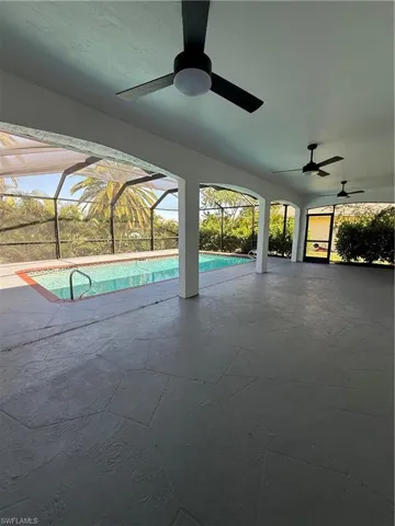 Swimming pool with a sunroom, glass enclosure, and a patio area