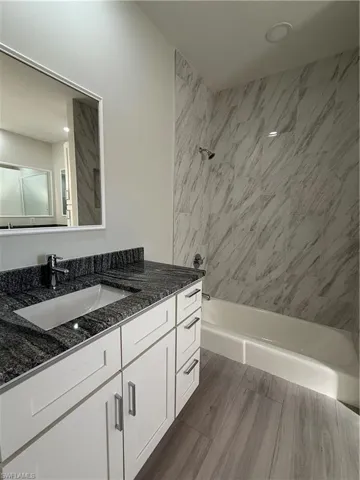 Bathroom featuring vanity and washtub / shower combination