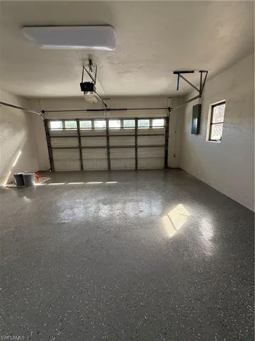 Garage featuring electric panel and a garage door opener