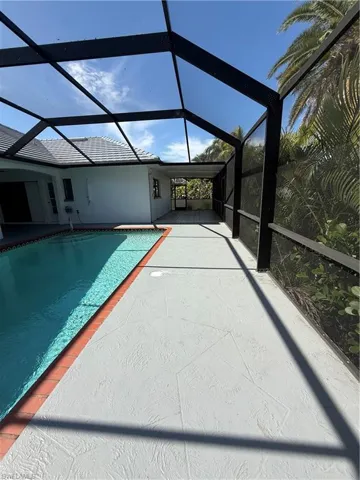 Outdoor pool featuring a sunroom, a lanai, and a patio area