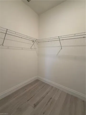 Walk in closet with light wood-style floors