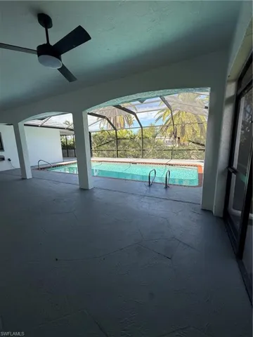Outdoor pool featuring a sunroom, a patio area, and glass enclosure