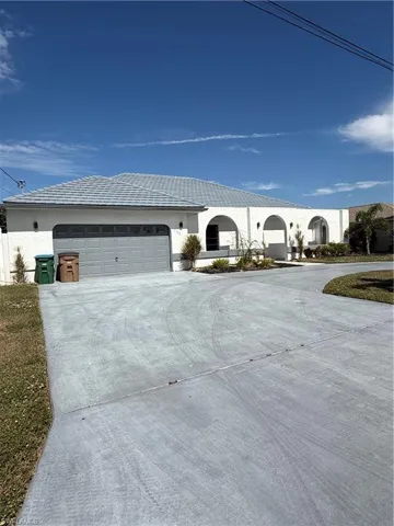 View of front of home with driveway, stucco siding, and a garage