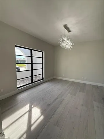 Unfurnished room with a chandelier and wood tiled floors