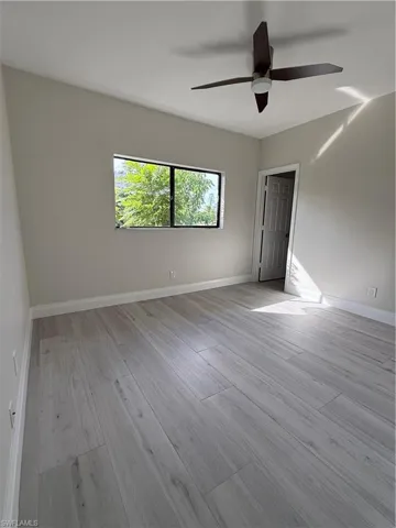 Empty room featuring light wood-type flooring and ceiling fan
