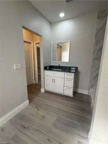 Full bath with vanity and light wood-style flooring