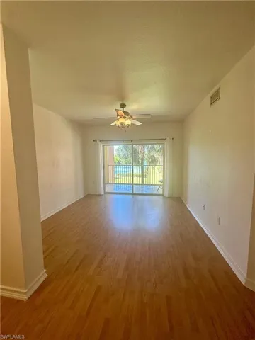 Unfurnished room with baseboards, wood finished floors, and ceiling fan