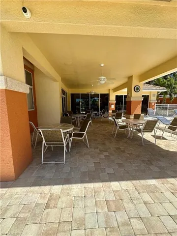 View of patio with ceiling fan and fence