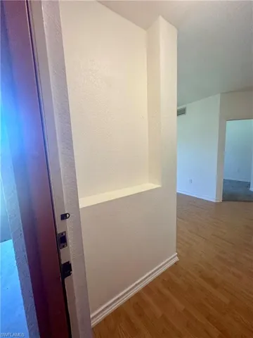 Hall with baseboards and wood finished floors