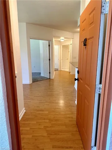 Hall with baseboards and light wood-type flooring