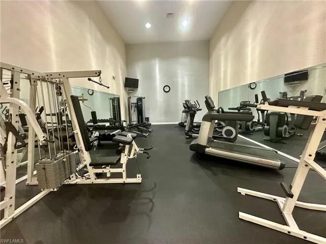 Exercise room featuring baseboards, visible vents, and a towering ceiling